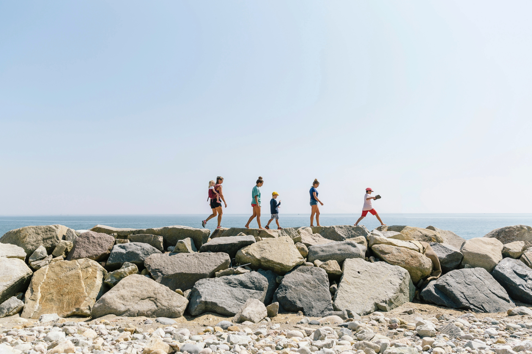 Family Walking Along Sea Wall at Beach